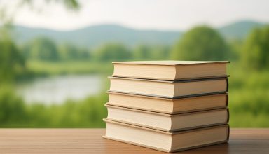 A stack of closed books on a wooden table with a blurred natural background